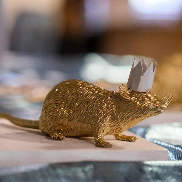 Fake gold rat wearing a paper crown