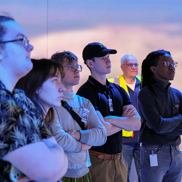 A group of students stands on a tour of Komatsu mining.